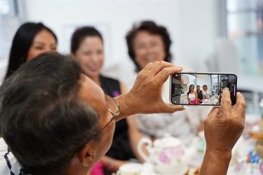 Guest takes photos during International Womens Day High Tea in Fairfield City HQ