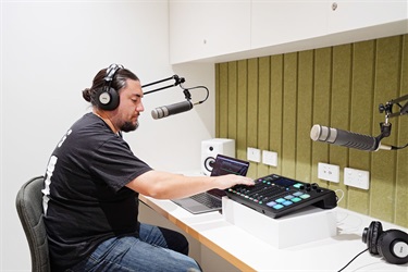 Male using audio equipment in Audio HQ at Fairfield City HQ