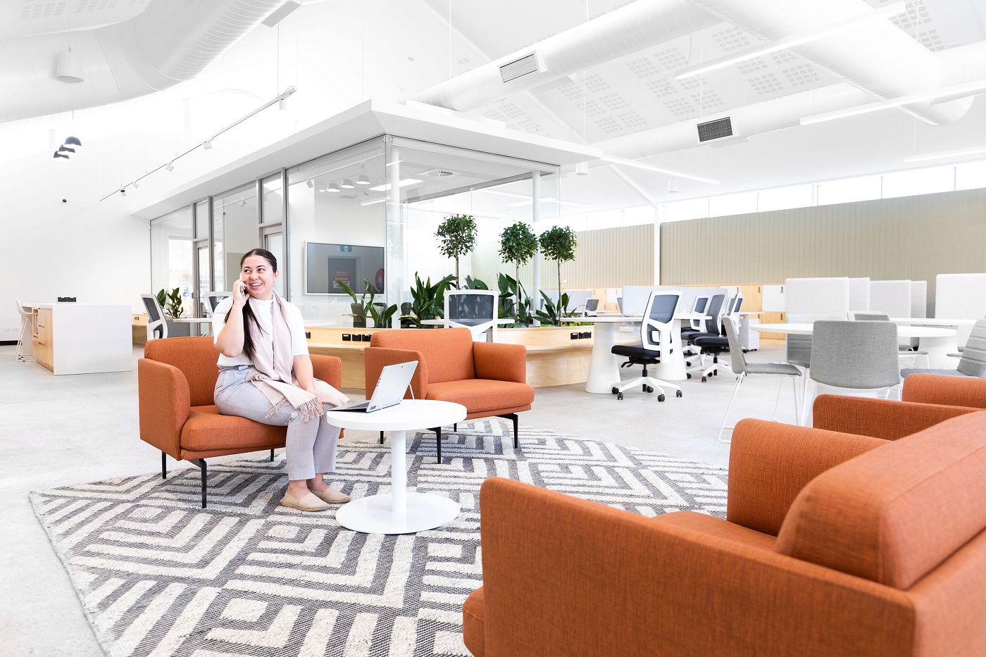 Smiling woman on phone call sitting on couch in Fairfield City HQ